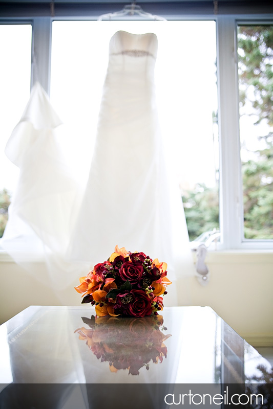 Sault Wedding - bouquet and dress on window